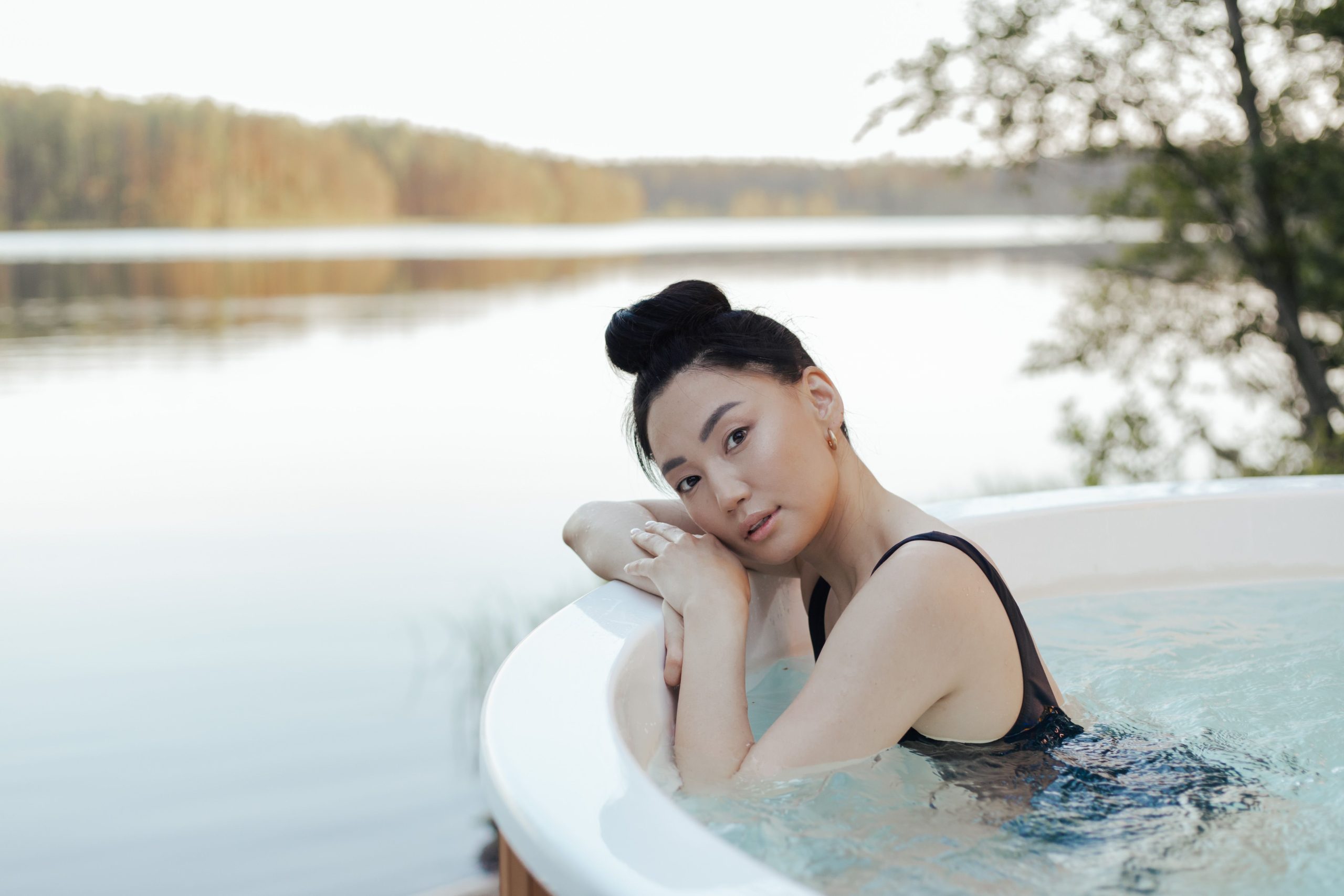Femme relaxant dans spa exterieur bord lac