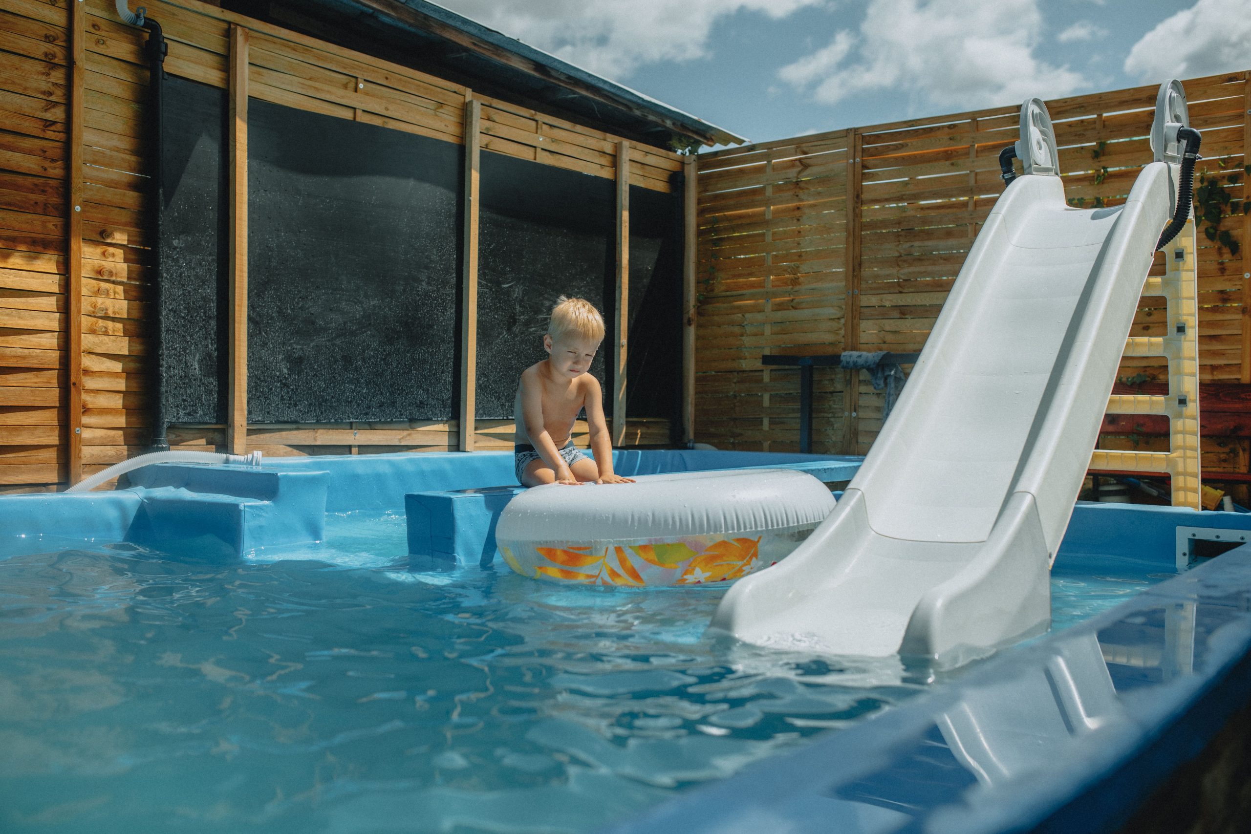 Enfant jouant dans piscine avec toboggan